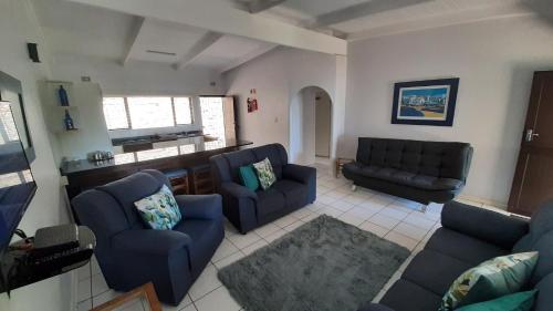 a living room with two blue couches and a kitchen at Villa Del Sol Unit 2 in Margate