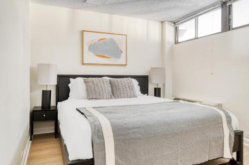 a white bedroom with a large bed and a window at Cambridge 2BR nr restaurants steps from Train BOS-517 in Cambridge