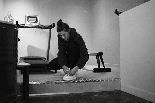 a woman sitting on a floor tying her shoes at The Originals City Hotel Artyster Clermont Ferrand in Clermont-Ferrand