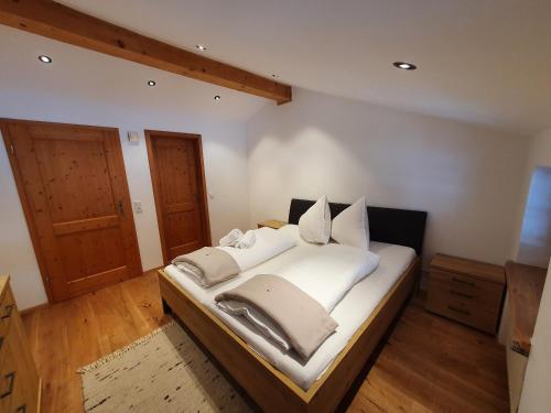 a bedroom with a bed with white sheets and pillows at Gasthof Zellerwand in Schleching