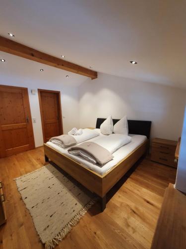 a bedroom with a bed with white sheets and pillows at Gasthof Zellerwand in Schleching