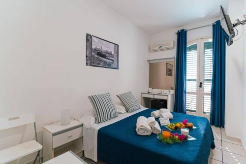 Un dormitorio con una cama y una mesa con fruta. en Hotel Le Dune en Sampieri