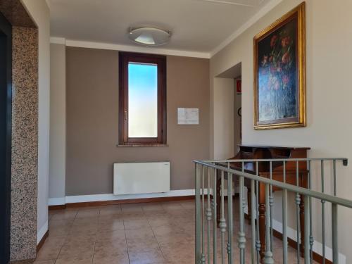 a hallway with a staircase and a window at Manfredi ristorante con alloggio in Romentino