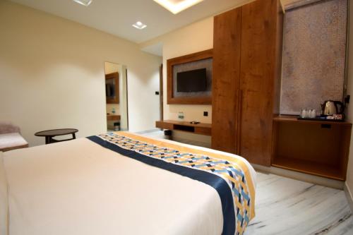 a hotel room with a bed and a television at The Sky Imperial Hotel Sugam - 10 Meters from Shrinathji Temple in Nāthdwāra