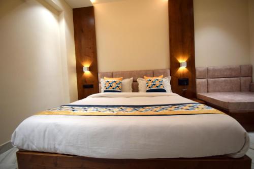 a bedroom with a large bed with two lights at The Sky Imperial Hotel Sugam - 10 Meters from Shrinathji Temple in Nāthdwāra