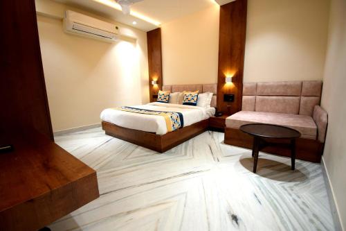 a hotel room with a bed and a chair at The Sky Imperial Hotel Sugam - 10 Meters from Shrinathji Temple in Nāthdwāra