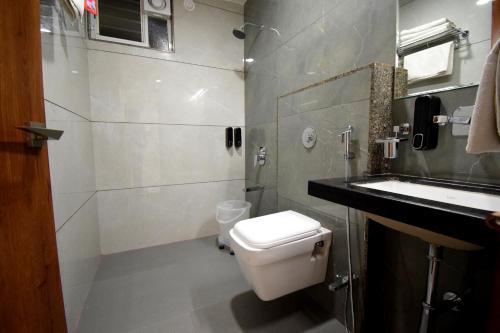 a bathroom with a white toilet and a sink at The Sky Imperial Hotel Sugam - 10 Meters from Shrinathji Temple in Nāthdwāra