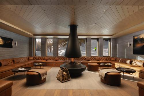 a large room with a couch and tables and windows at Six Senses Crans-Montana in Crans-Montana