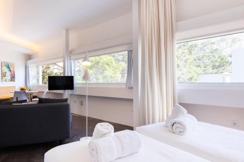 um quarto de hotel com duas camas brancas e uma janela em Home2Book Casablanca Las Teresitas Beach em San Andrés