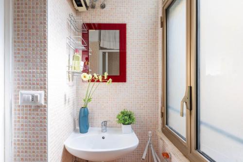 un bagno con un lavandino bianco e uno specchio di iFlat Little flat in Testaccio perfect WFP, WIND, FAO a Roma
