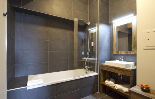 La salle de bains est pourvue d'une baignoire et d'un lavabo. dans l'établissement Appart'Hôtel Prestige Odalys L'Eclose, à L'Alpe-d'Huez