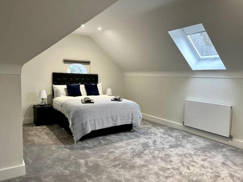 a bedroom with a large bed with a skylight at Luxury 3 Bed House w Parking & Garden! 1 in Bournemouth