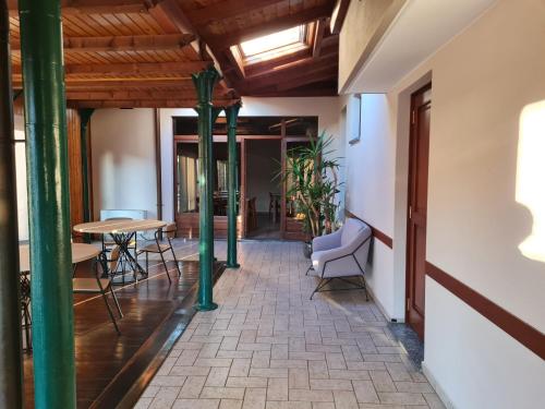 a hallway with green columns and a table and chairs at Manfredi ristorante con alloggio in Romentino