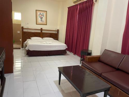 a hotel room with a bed and a couch at KUHARA COURT APARTMENT SUITE in Tawau
