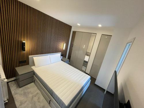 una piccola camera con letto bianco e specchio di Luxury Pure! Bazzoni 2-room Suite, fully equipped a Olbia