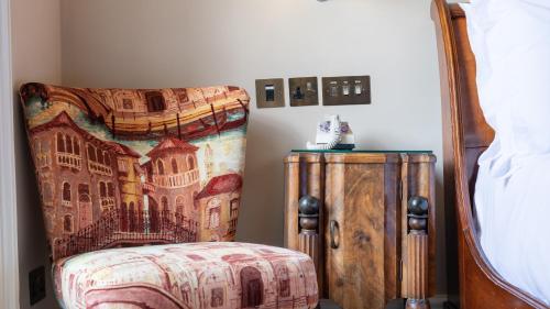 a bedroom with a bed and a dresser next to a bed at Southernhay House Hotel in Exeter