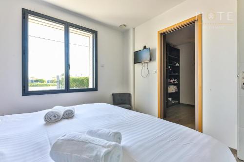 1 dormitorio con 1 cama blanca grande y toallas. en Grande Villa dans les marais Olonnais, en Olonne-sur-Mer
