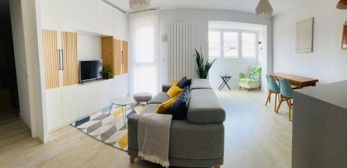 ein Wohnzimmer mit einem Sofa und einem Esszimmer in der Unterkunft Apartamento Donostia San Sebastian in Loyola