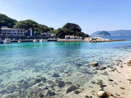 a beach with clear blue water and a rocky shore at 柏島ヴィレッジ in Otsuki