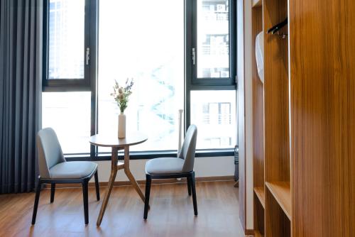 a table and chairs in a room with a window at Hotel Arari in Jeonju