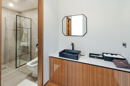 a bathroom with a sink and a toilet and a mirror at Hotel Arari in Jeonju