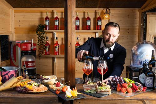 a man pouring a glass of wine at a table at Novotel Roma Est in Rome