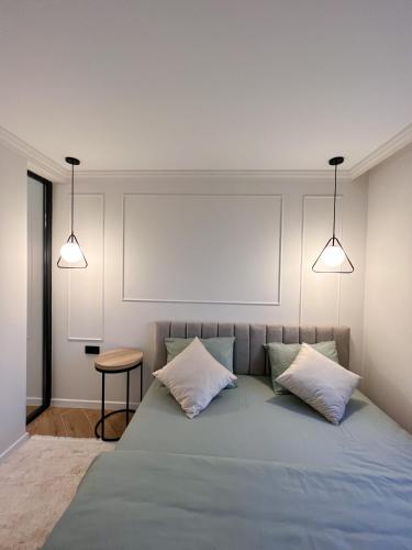 a bedroom with a bed with two pillows and two lights at RentHouse Apartments Neoclassic in Chişinău