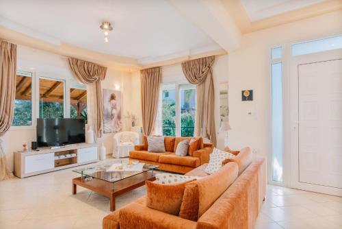 a living room with a couch and a tv at Propodes Luxury Villa in Pastida