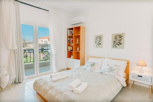 a white bedroom with a large bed and a window at Propodes Luxury Villa in Pastida
