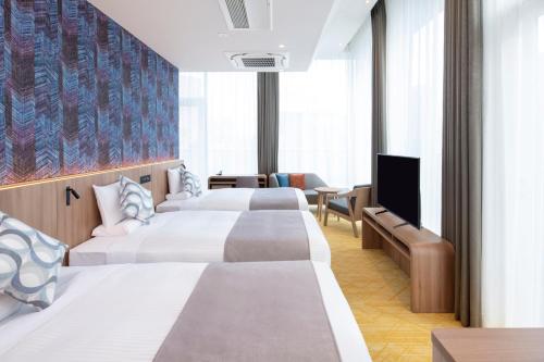 HOTEL MYSTAYS Nishi Shinjuku في طوكيو: غرفة فندقية بسريرين وتلفزيون بشاشة مسطحة
