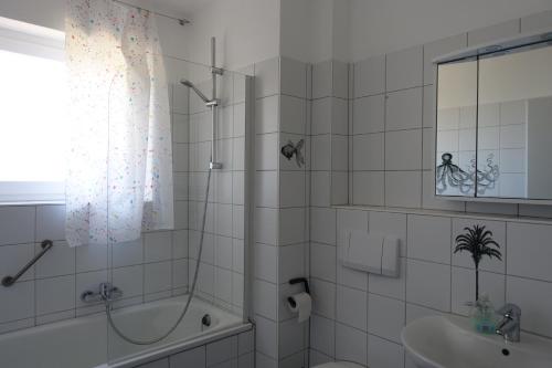 biała łazienka z prysznicem i umywalką w obiekcie Ferienwohnung im Kieler Süden w Kilonii