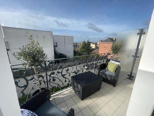 a balcony with chairs and tables on a balcony at ALP Chartres - Grand studio avec terrasse et parking in Chartres