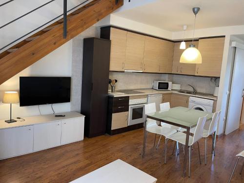 a kitchen with a table and a dining room at Apartamentos Ordesa Infinita in Asín de Broto