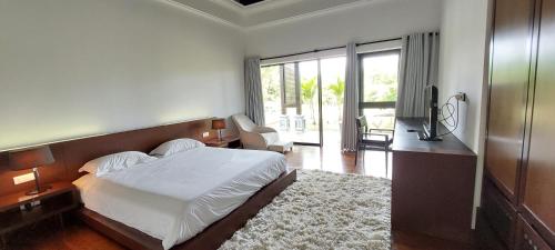 a bedroom with a bed and a television in it at Villa Ventura in Bel Ombre