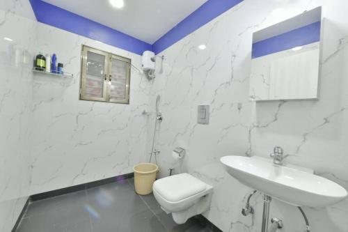 Baño blanco con lavabo y aseo en Lobville Homestay- Karjat. Peace amidst Nature., en Karjat