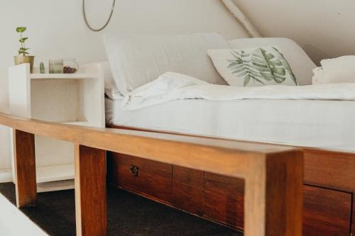 a bed in a room with a wooden table at Central Loft 2-3 mins away from Surf Spots in General Luna