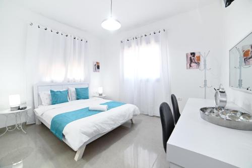 a white bedroom with a bed and a sink at Kineret sheli- 4Bedrooms luxury apartment with stunning lake view in Tiberias