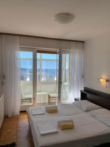 - une chambre avec un grand lit et une grande fenêtre dans l'établissement Vila Primo, à Primošten
