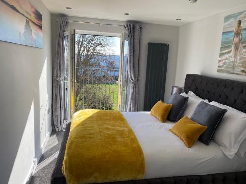 a bedroom with a large bed with a yellow blanket at The Penthouse - Luxury 2 Bed Apartment in Skegness