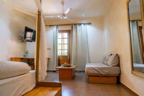 a room with a bed and a mirror and a window at Casa Mara Dakar in Dakar