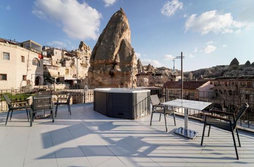 a patio with a table and chairs and a mountain at The Niche Cave Hotel in Göreme