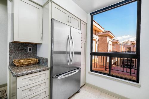 a kitchen with a stainless steel refrigerator and a window at Shores At Waikoloa Beach Resort 332 in Waikoloa