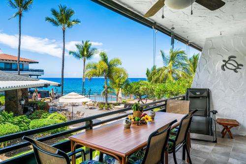 a table and chairs on a balcony with a view of the ocean at Casa De Emdeko 235 in Kailua-Kona