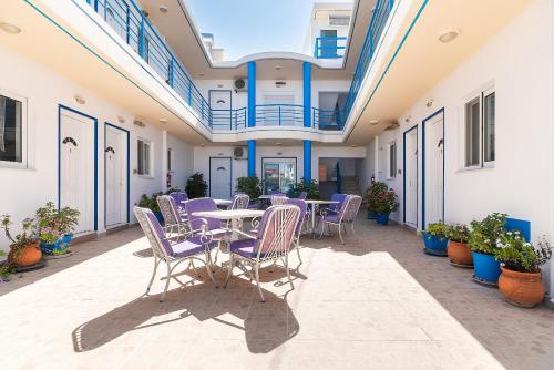 a patio with purple chairs and a table in a building at Acapulco 6 in Afantou