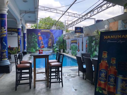 a bar with chairs and a table with bottles of beer at The Eighty8 in Phnom Penh