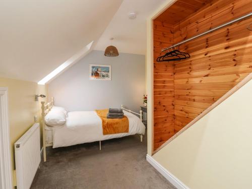 a small bedroom with a bed and a staircase at The Beach Huts in Hornsea