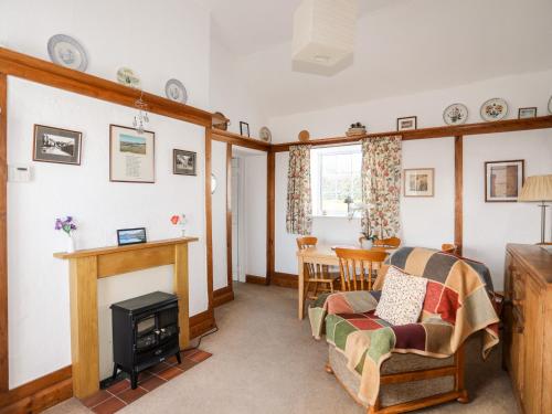 a living room with a fireplace and a table at Ty Hir in Llangoed