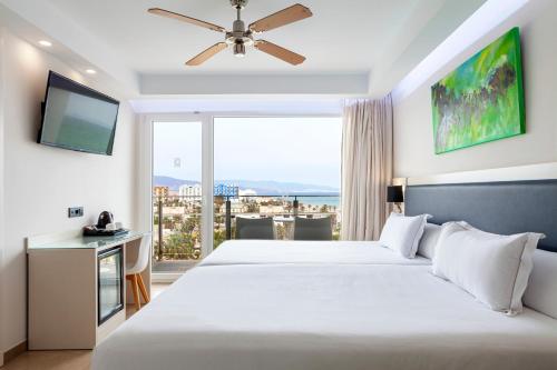 sypialnia z dużym łóżkiem i dużym oknem w obiekcie Playasol w mieście Roquetas de Mar