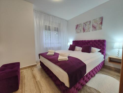 um quarto com uma cama grande e uma cabeceira de cama roxa em Velika Recepcija 7 em Zlatibor