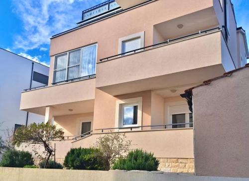 - un grand bâtiment avec des balcons sur le côté dans l'établissement Apartman M&B, à Vodice